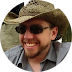 smiling man with goatee, sunglasses, and cowboy hat