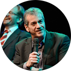 older man in suit holding a microphone