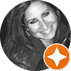 A black and white close-up portrait of Renee R. smiling warmly with long, flowing hair.